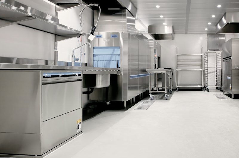 Commercial kitchen with stainless equipment and a seamless floor